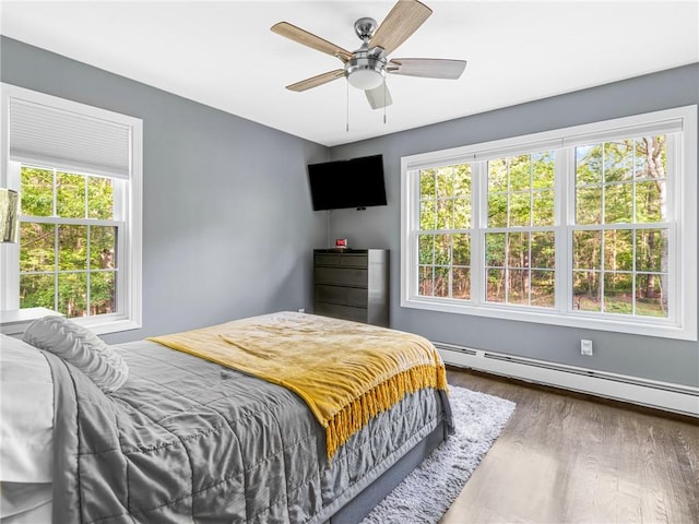 511 Central Pike, Scituate, RI 02857 - bedroom featuring multiple windows, baseboard heating, wood finished floors, and ceiling fan