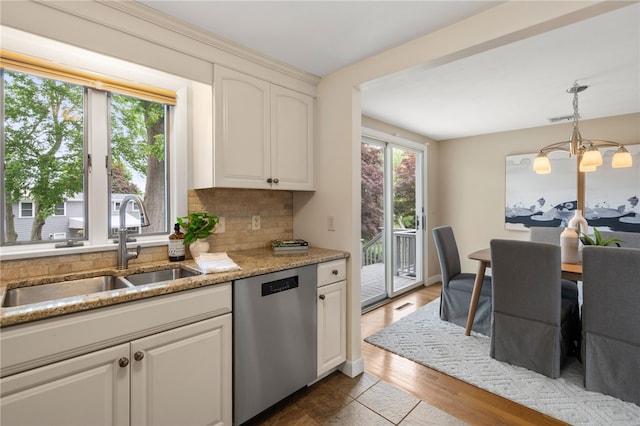 45 Landon Rd, Warwick, RI 02888 - kitchen with stainless steel dishwasher, a sink, backsplash, a chandelier, and hanging light fixtures