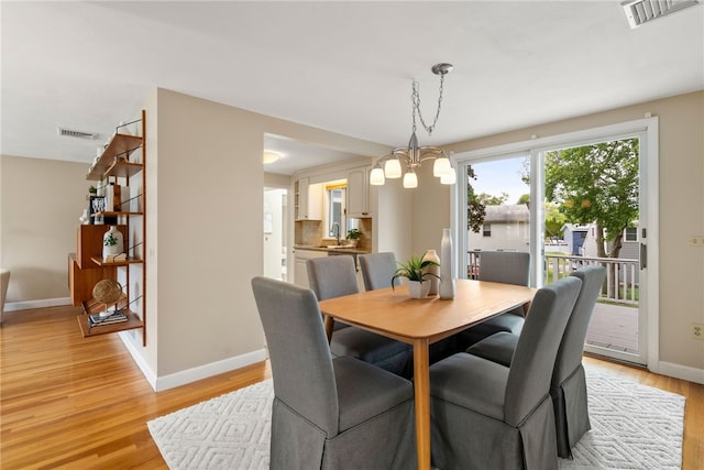 45 Landon Rd, Warwick, RI 02888 - dining area featuring a chandelier, baseboards, and light wood-style flooring
