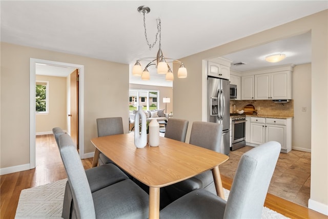 45 Landon Rd, Warwick, RI 02888 - dining room with a chandelier, light wood-style flooring, and baseboards