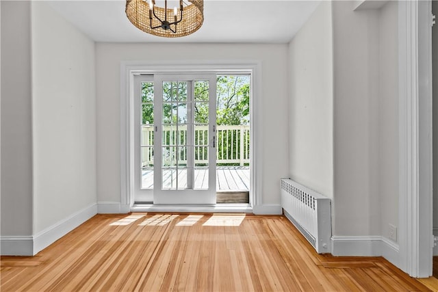 4 Red Cross Ave Unit 4, Newport, RI 02840 - entryway featuring radiator heating unit, a chandelier, light wood-type flooring, and baseboards