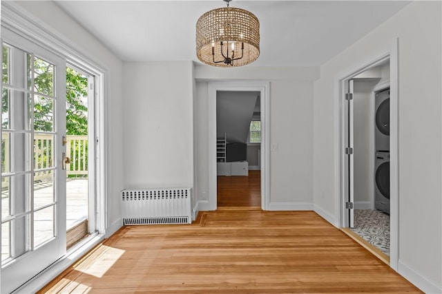 4 Red Cross Ave Unit 4, Newport, RI 02840 - unfurnished dining area with radiator heating unit, stacked washing machine and dryer, a chandelier, and light wood-type flooring