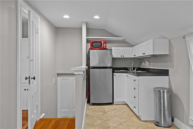 4 Red Cross Ave Unit 4, Newport, RI 02840 - kitchen with freestanding refrigerator, a sink, white cabinets, vaulted ceiling, and dark countertops