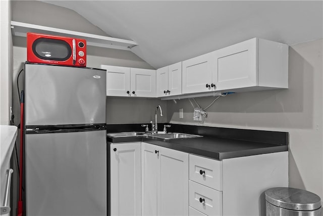 4 Red Cross Ave Unit 4, Newport, RI 02840 - kitchen with freestanding refrigerator, vaulted ceiling, dark countertops, a sink, and white cabinetry