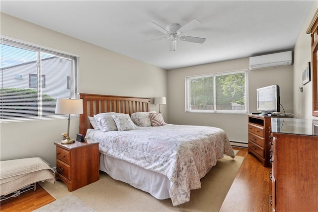 30 Sweet Meadow Ct Unit 15, Narragansett, RI 02882 - bedroom featuring a wall unit AC, light wood-style flooring, a baseboard heating unit, and ceiling fan