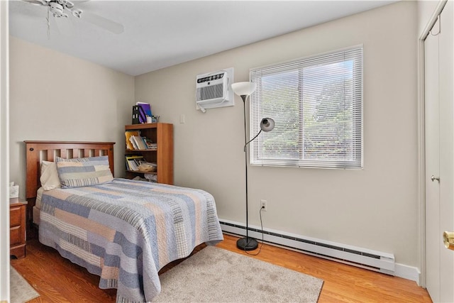 30 Sweet Meadow Ct Unit 15, Narragansett, RI 02882 - bedroom featuring a baseboard heating unit, light wood finished floors, a wall mounted AC, and a ceiling fan