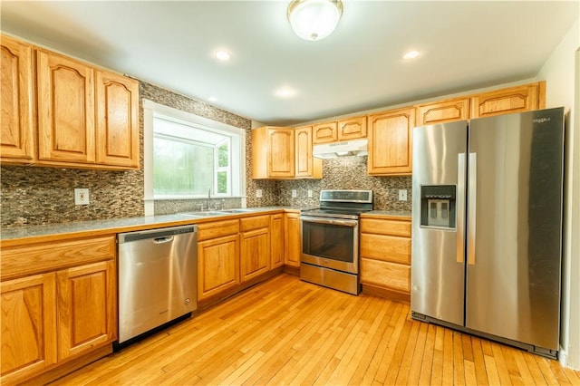 235 Spring St, Hopkinton, RI 02832 - kitchen featuring stainless steel appliances, under cabinet range hood, a sink, light wood finished floors, and decorative backsplash