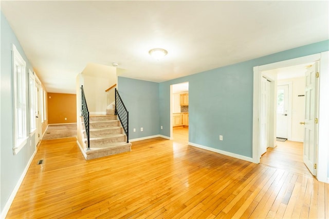 235 Spring St, Hopkinton, RI 02832 - unfurnished living room with light wood finished floors, baseboards, and stairs