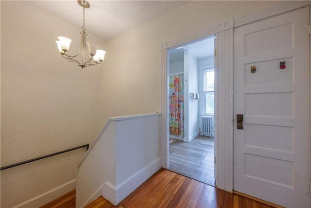 16 Malvern Ave, Cranston, RI 02905 - stairs with radiator, wood finished floors, baseboards, and a chandelier