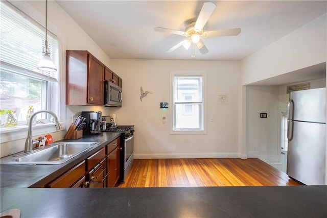 16 Malvern Ave, Cranston, RI 02905 - kitchen with stainless steel appliances, dark countertops, light wood-style flooring, a sink, and baseboards