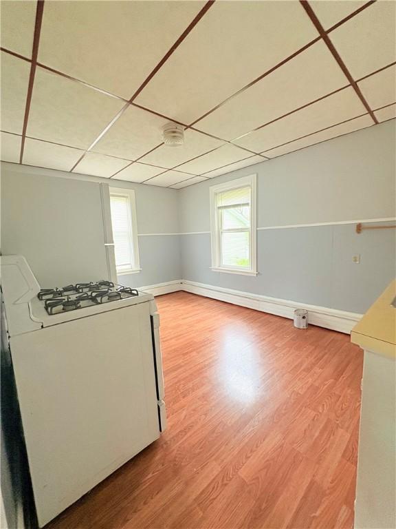 74 Pontiac St, Warwick, RI 02886 - kitchen featuring white gas range, light wood finished floors, baseboards, and a paneled ceiling