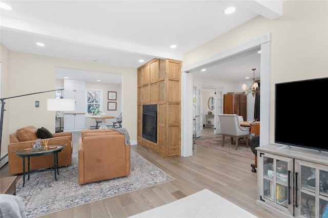 58 Austin St, South Kingstown, RI 02879 - living area with light wood-type flooring, recessed lighting, a fireplace, and a chandelier