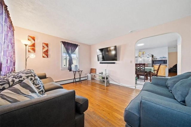 320 Beverage Hill Ave, Pawtucket, RI 02861 - living room with a baseboard radiator, arched walkways, light wood-style floors, and baseboards