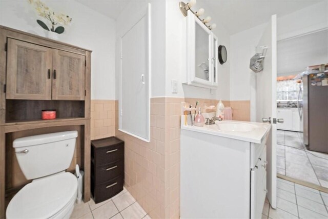 320 Beverage Hill Ave, Pawtucket, RI 02861 - bathroom featuring tile walls, tile patterned flooring, vanity, toilet, and a wainscoted wall