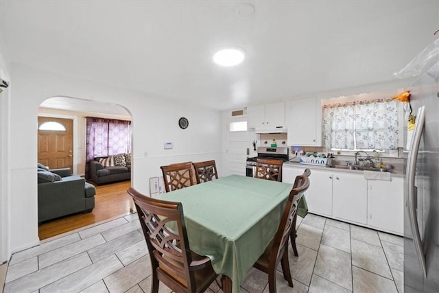 320 Beverage Hill Ave, Pawtucket, RI 02861 - dining space with arched walkways, light tile patterned flooring, and plenty of natural light