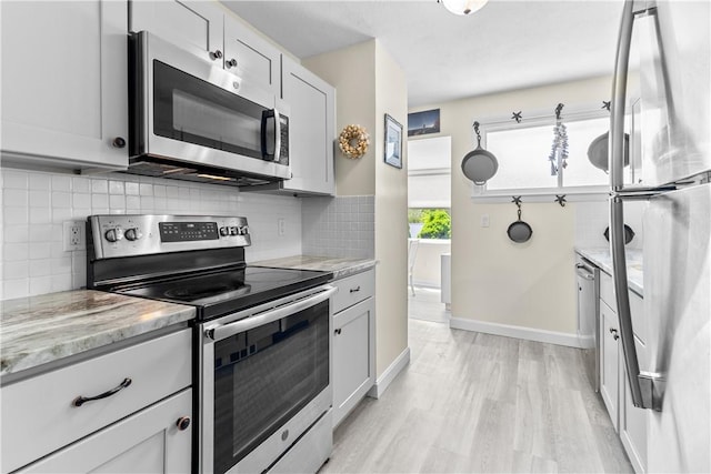 30 Brown St Unit 2, Narragansett, RI 02882 - kitchen with stainless steel appliances, light wood finished floors, backsplash, and baseboards