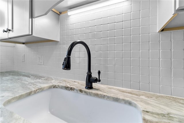 30 Brown St Unit 2, Narragansett, RI 02882 - kitchen view of a sink, backsplash, white cabinets, and light stone countertops