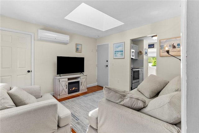 30 Brown St Unit 2, Narragansett, RI 02882 - living room with an AC wall unit, a skylight, wood finished floors, baseboards, and a glass covered fireplace