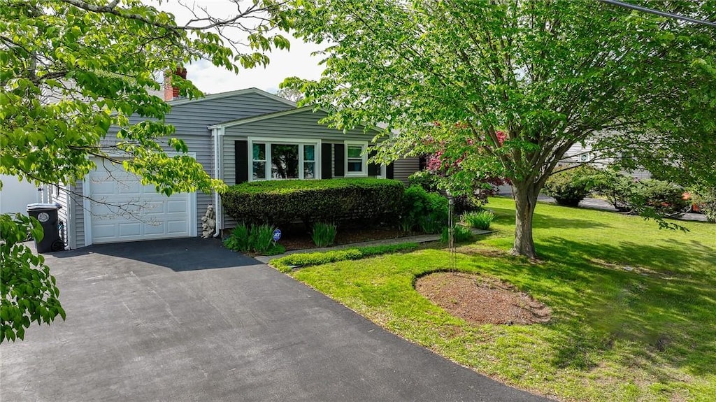 11 Laurelhurst Rd, Cranston, RI 02920 - view of front of house featuring asphalt driveway, a front yard, a garage, and a chimney
