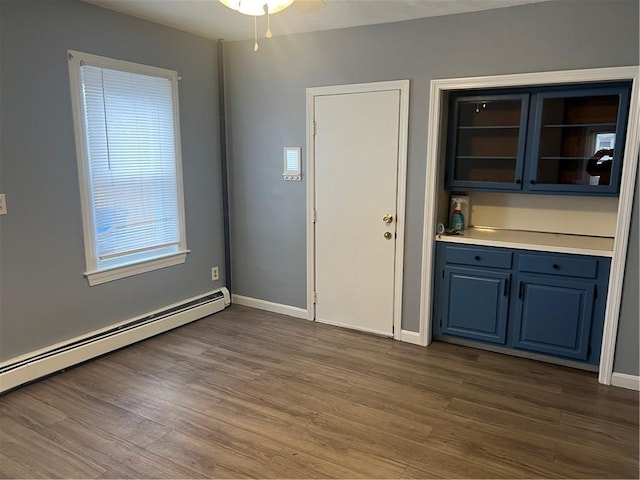 1097 Pontiac Ave, Cranston, RI 02910 - unfurnished dining area featuring baseboard heating, dark wood-type flooring, and baseboards