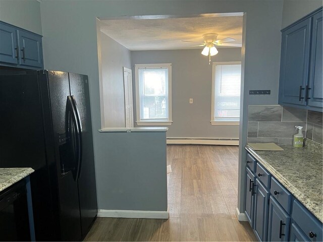 1097 Pontiac Ave, Cranston, RI 02910 - kitchen with black fridge, ceiling fan, blue cabinetry, and baseboard heating