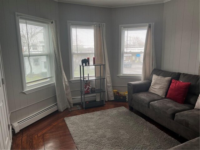 1097 Pontiac Ave, Cranston, RI 02910 - living room featuring a baseboard radiator, plenty of natural light, dark wood-style floors, ornamental molding, and wooden walls