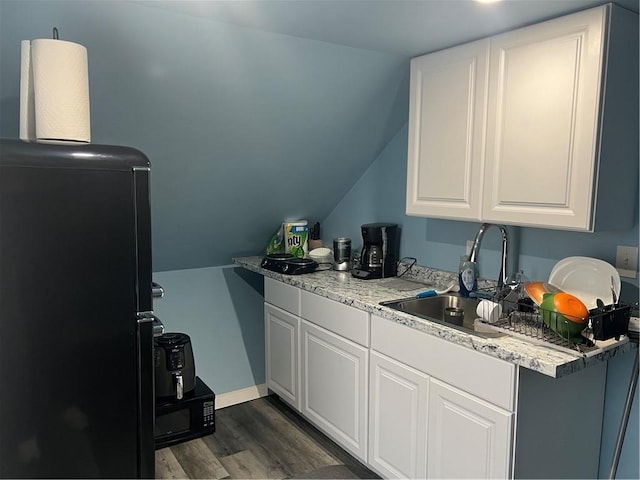1097 Pontiac Ave, Cranston, RI 02910 - kitchen with refrigerator, dark wood-style floors, light countertops, white cabinetry, and vaulted ceiling