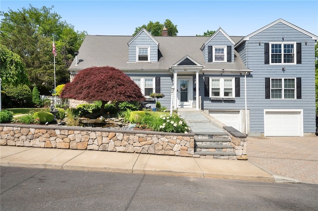 62 Andrews Ave, West Warwick, RI 02893 - view of front of home featuring an attached garage, driveway, and a chimney