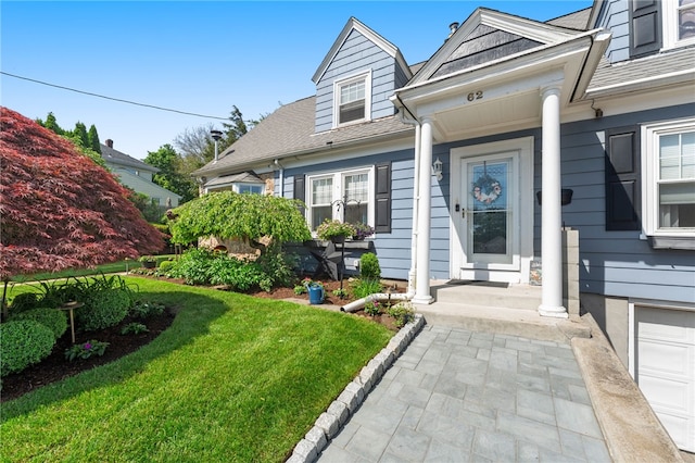 62 Andrews Ave, West Warwick, RI 02893 - doorway to property featuring a lawn and a shingled roof