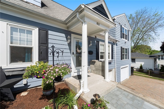 62 Andrews Ave, West Warwick, RI 02893 - view of exterior entry with decorative driveway and a shingled roof