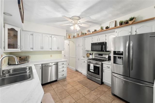 62 Andrews Ave, West Warwick, RI 02893 - kitchen featuring stainless steel appliances, a sink, light tile patterned floors, light countertops, and white cabinetry