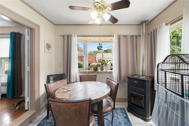 62 Andrews Ave, West Warwick, RI 02893 - dining area with a wood stove, ceiling fan, light tile patterned flooring, and ornamental molding