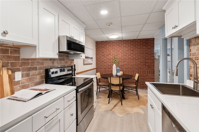 22 Halsey St Unit 1, Providence, RI 02906 - kitchen featuring stainless steel appliances, a sink, a paneled ceiling, light countertops, and white cabinets
