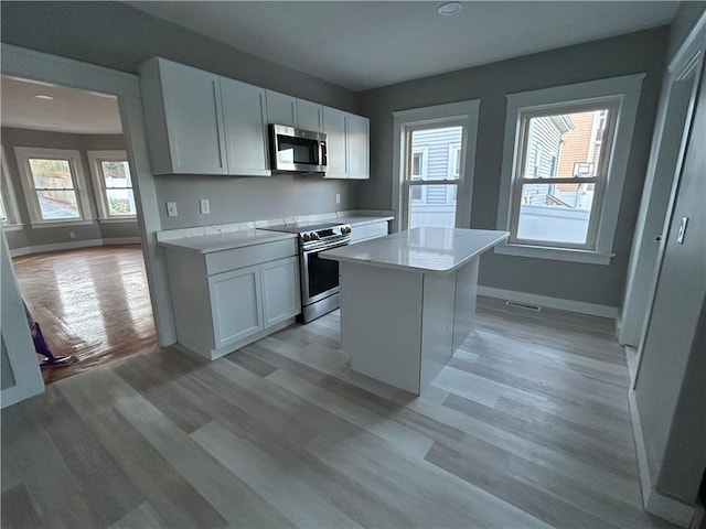 26 Mayflower St, East Providence, RI 02914 - kitchen featuring stainless steel appliances, light countertops, white cabinetry, light wood-type flooring, and recessed lighting