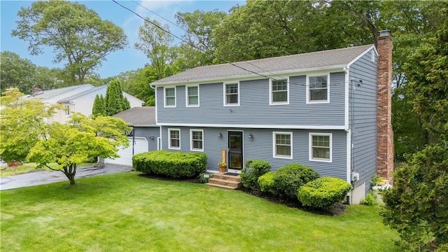 67 Hathaway Dr, West Warwick, RI 02893 - colonial home with a chimney, a front lawn, and view of scattered trees