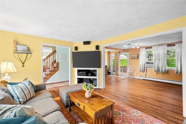 67 Hathaway Dr, West Warwick, RI 02893 - living area featuring a baseboard heating unit, wood finished floors, stairway, baseboards, and cooling unit