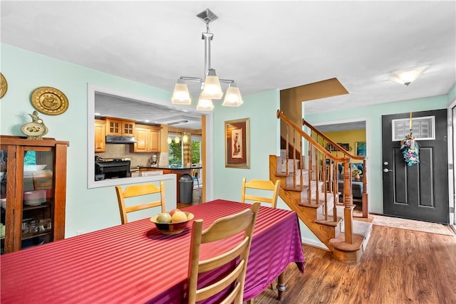 67 Hathaway Dr, West Warwick, RI 02893 - dining room featuring wood finished floors, stairs, and a chandelier