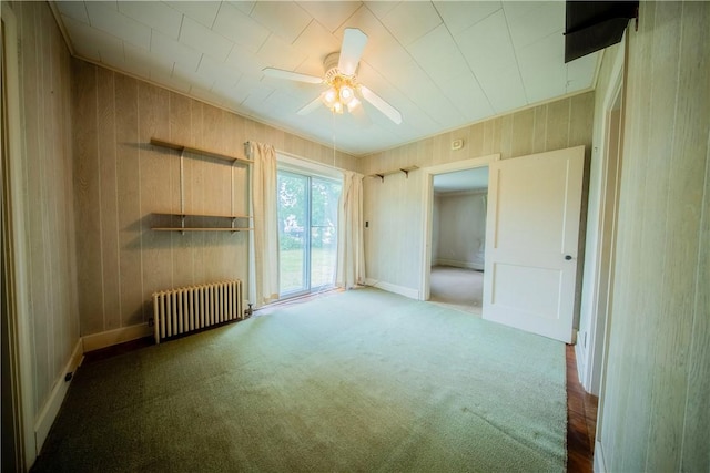 102 Buttonwoods Ave, Warwick, RI 02886 - unfurnished bedroom with radiator, carpet flooring, wooden walls, a ceiling fan, and access to exterior