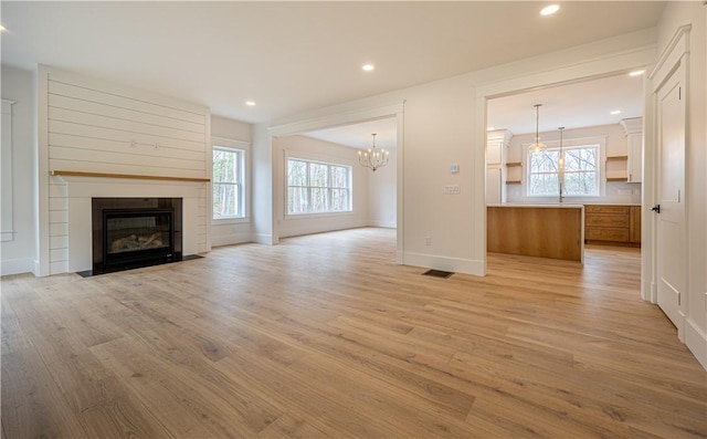 757 Cooper Rd, Glocester, RI 02814 - unfurnished living room featuring light wood-type flooring, plenty of natural light, a chandelier, a fireplace, and recessed lighting