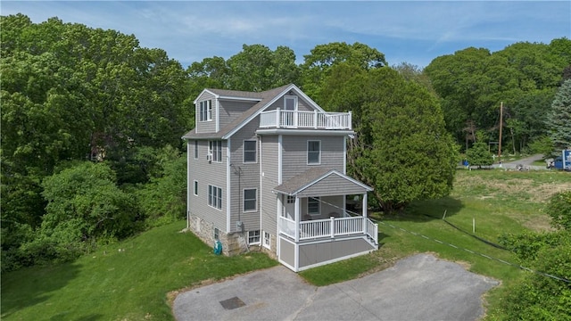 126 Hilton St, Tiverton, RI 02878 - rear view of house with a balcony, a lawn, and a view of trees