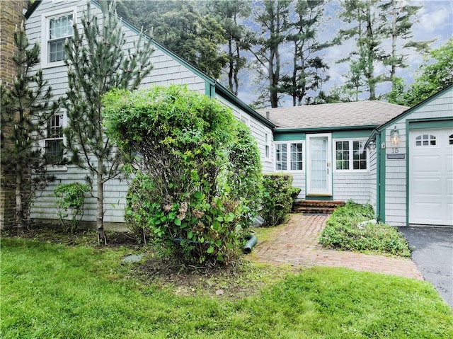 15 Franconia Dr, Cranston, RI 02920 - view of front of home featuring a front lawn, an attached garage, roof with shingles, and asphalt driveway