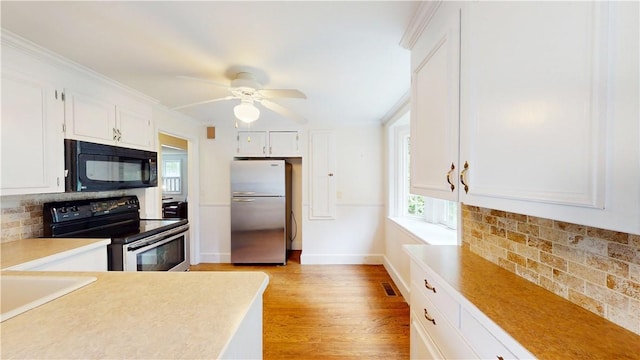 15 Franconia Dr, Cranston, RI 02920 - kitchen with freestanding refrigerator, black microwave, electric stove, decorative backsplash, and white cabinetry