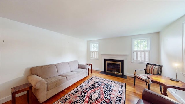 15 Franconia Dr, Cranston, RI 02920 - living room with healthy amount of natural light, a fireplace with flush hearth, light wood-style floors, and baseboards