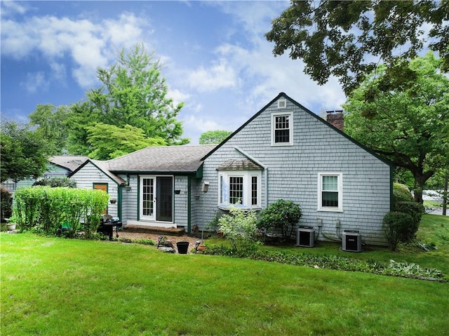 15 Franconia Dr, Cranston, RI 02920 - rear view of house featuring a chimney, a yard, and central AC unit