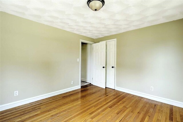 23 Robert Cir, Cranston, RI 02905 - unfurnished bedroom featuring baseboards, wood finished floors, and a closet
