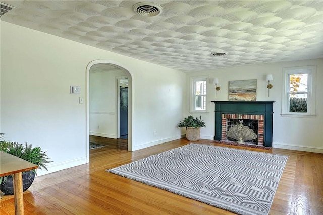 23 Robert Cir, Cranston, RI 02905 - living area featuring arched walkways, baseboards, wood finished floors, and a fireplace