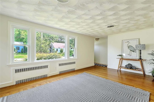 23 Robert Cir, Cranston, RI 02905 - spare room featuring radiator heating unit, wood finished floors, and baseboards