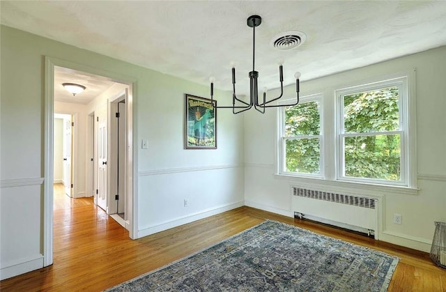 23 Robert Cir, Cranston, RI 02905 - unfurnished dining area with radiator heating unit, a chandelier, plenty of natural light, and wood finished floors