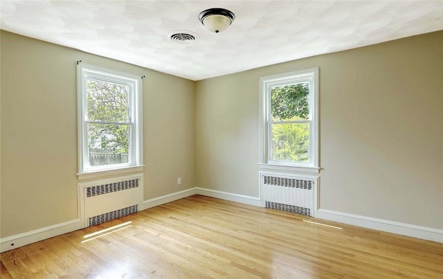 23 Robert Cir, Cranston, RI 02905 - spare room with radiator, plenty of natural light, and wood finished floors