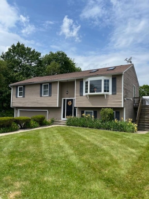 80 Capwell Ave, Woonsocket, RI 02895 - raised ranch with stairs, a front lawn, an attached garage, and a wooden deck